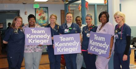 一群护士连续站立。有些人持有团队肯尼迪克里格标志。